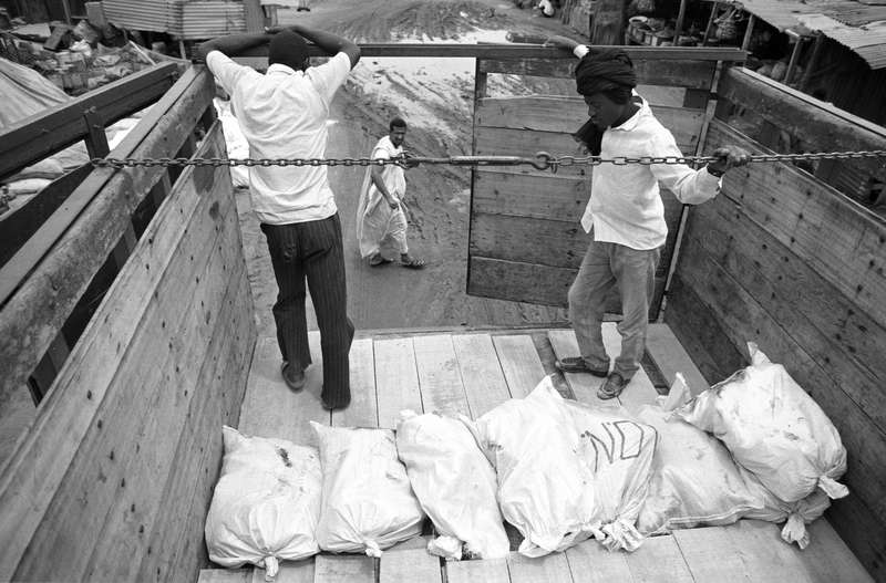 Chargement de sacs de sel (de terre) dans un camion par des Haratines, Nouakchott, 1993, Ph. Moctar KANE