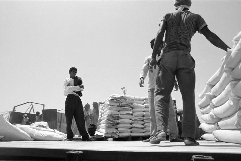 Chargement de sacs de farine dans des camions par des Haratines, port de Nouakchott, 1993, Ph. Moctar KANE.
